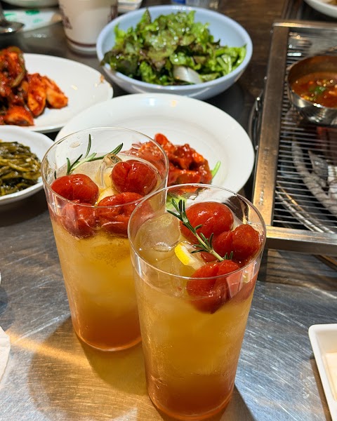 Tall glasses of iced tea topped with cherry tomatoes and rosemary sprigs
