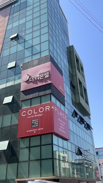 Modern glass commercial building exterior in Gangnam showing signage for Color Place