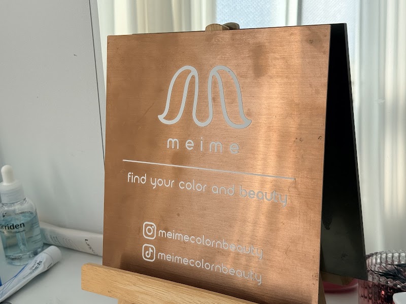 Metallic copper branding plaque on wooden easel inside Meime studio