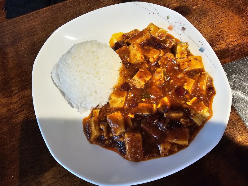 Plate of savory mapo tofu with a scoop of white steamed rice