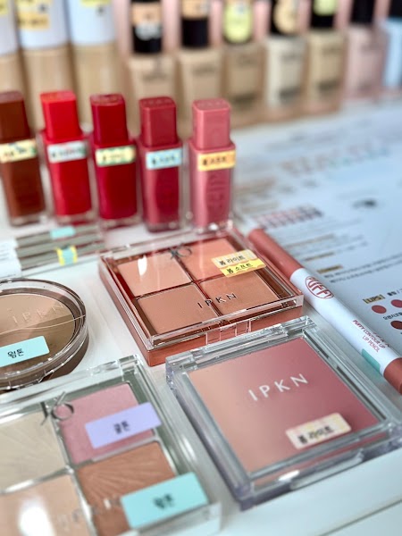 Selection of cosmetic products including lip tints, eye shadow palettes, and blush on a white surface with color labels.