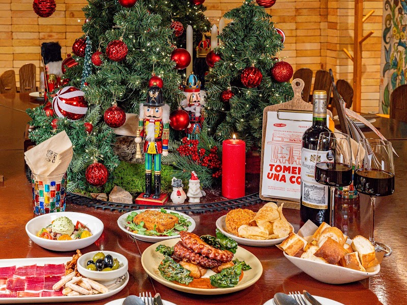 Festive dining table arranged with Spanish tapas, wine glasses, and a bottle of wine