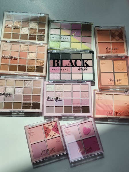 A collection of ten cosmetic eyeshadow and blush palettes arranged on a plain white surface.
