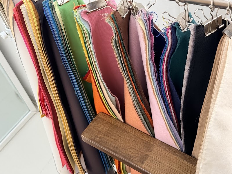Collection of seasonal fabric swatches hanging on studio racks for color analysis