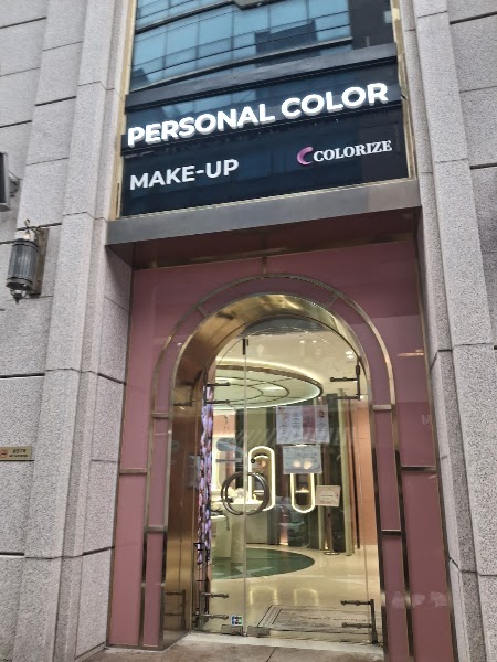 Exterior entrance of Colorize studio in Seoul with pink arched door frame and illuminated signage