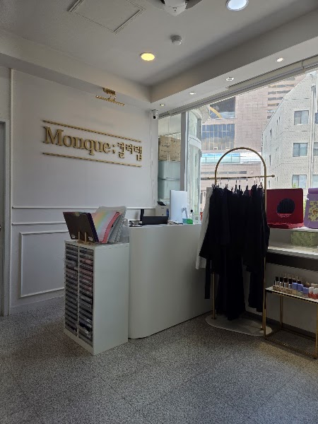 Monque Colorlab reception area with studio signage and curated garment rack