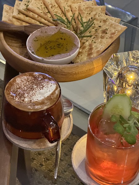 Table setting with herb crackers, savory dip, and evening cocktails