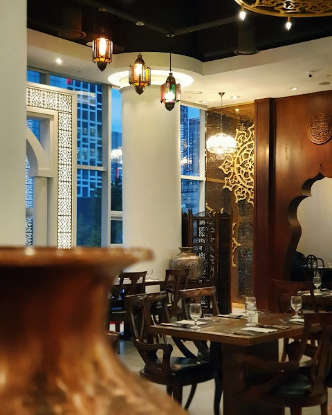 Interior view of Saffron halal restaurant in Seoul featuring Middle Eastern decor, wooden tables, and pendant lanterns