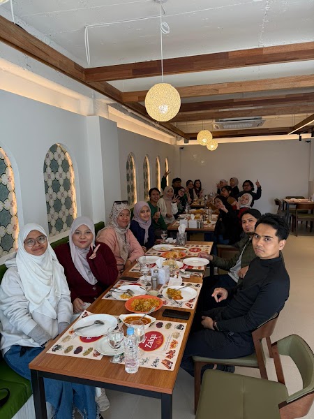Group dining gathering enjoying shared meal at long wooden tables