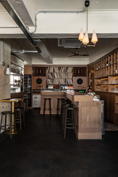 Central wooden bar counter and illuminated vinyl record display at Komfy Samgakji