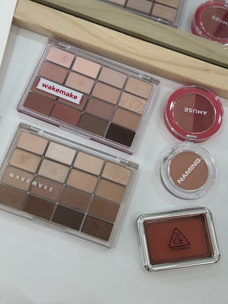 Flat lay of neutral-toned eyeshadow and blush compacts on consultation table
