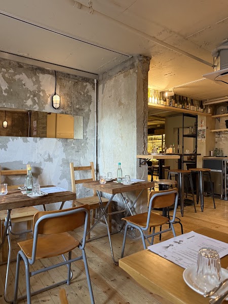 Interior dining room at Birch Seoul with wooden tables, concrete walls, and warm lighting