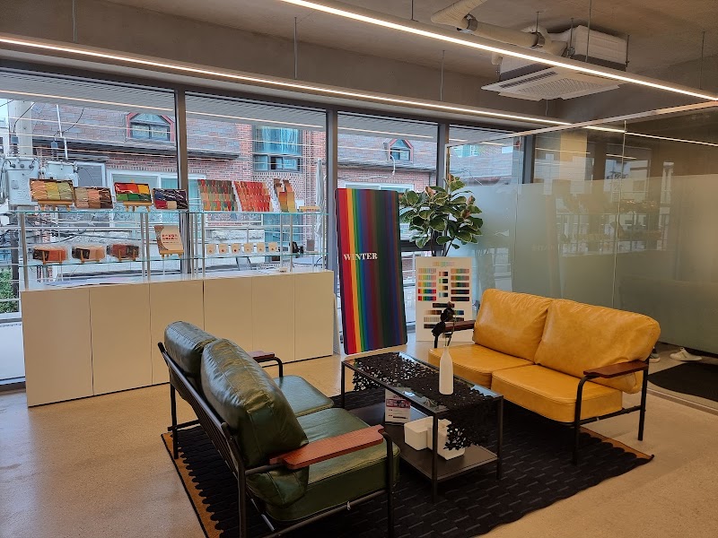 Interior of COCORY Color consultant office featuring a seating area with green and yellow leather sofas and color analysis displays.