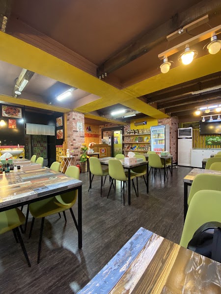 Interior of Bakso Bejo restaurant in Seoul with green chairs and tables