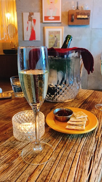 A champagne flute and crackers on a rustic wooden table at a bistro.