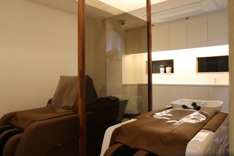 Modern hair washing and headspa stations in minimalist light-toned studio