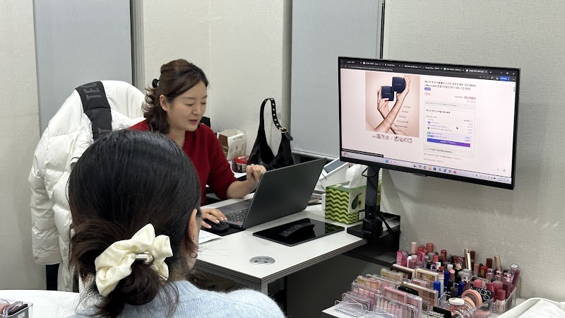 Consultant conducting a personal color analysis session with digital screen and cosmetic tools