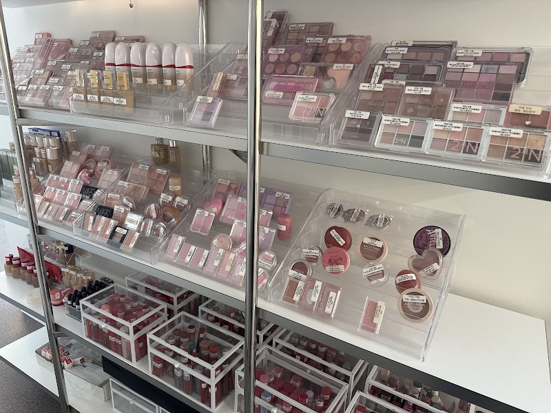 Organized collection of cosmetic palettes and beauty products on tiered shelves in a consultation studio