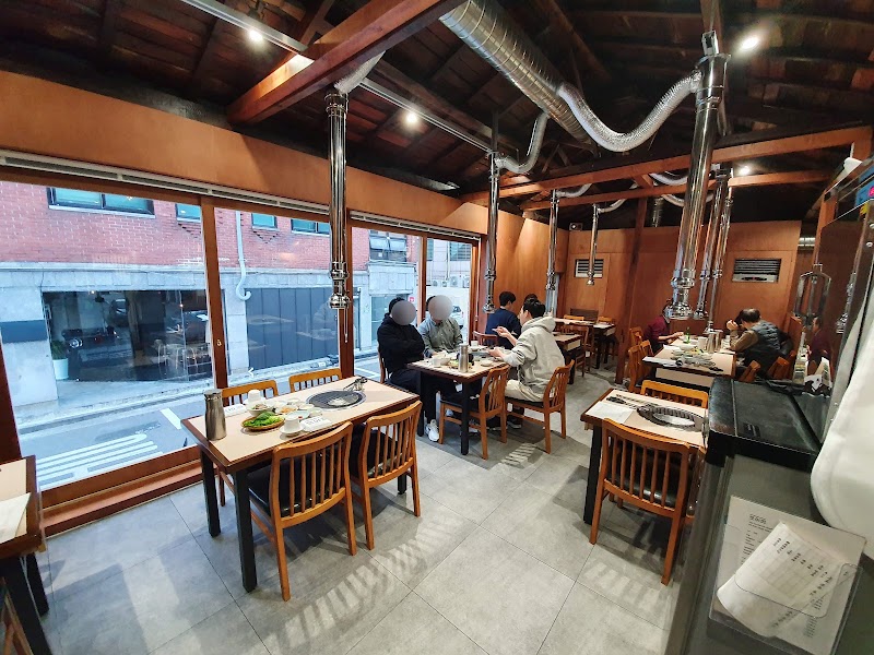 Interior view of Doyajib Korean BBQ restaurant in Seoul with wooden paneling and exposed rafters