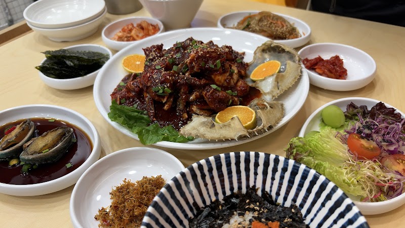 A table set with a variety of Korean side dishes, seasoned banchan, and fresh salad