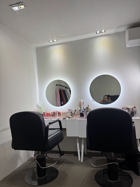 Two black consultation chairs facing circular illuminated mirrors