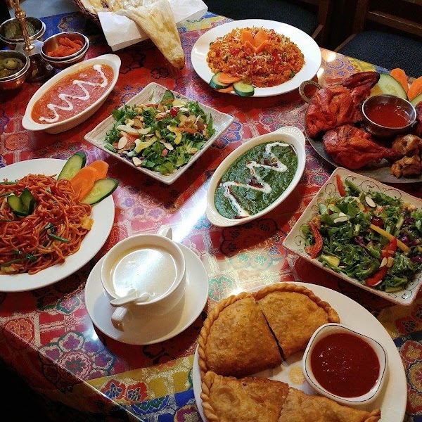 A spread of various Indian dishes on a patterned table at Gurkha Indian Restaurant in Seoul