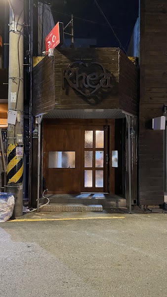 Nighttime facade of B421 restaurant featuring dark horizontal wood paneling