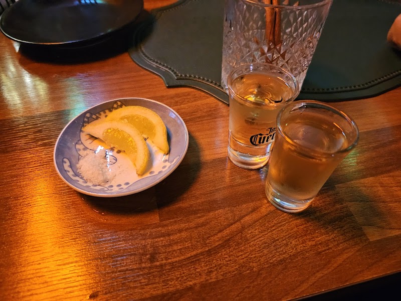 Two shot glasses with golden liquor and a small plate with lemon wedges and salt at Liverpool Pub