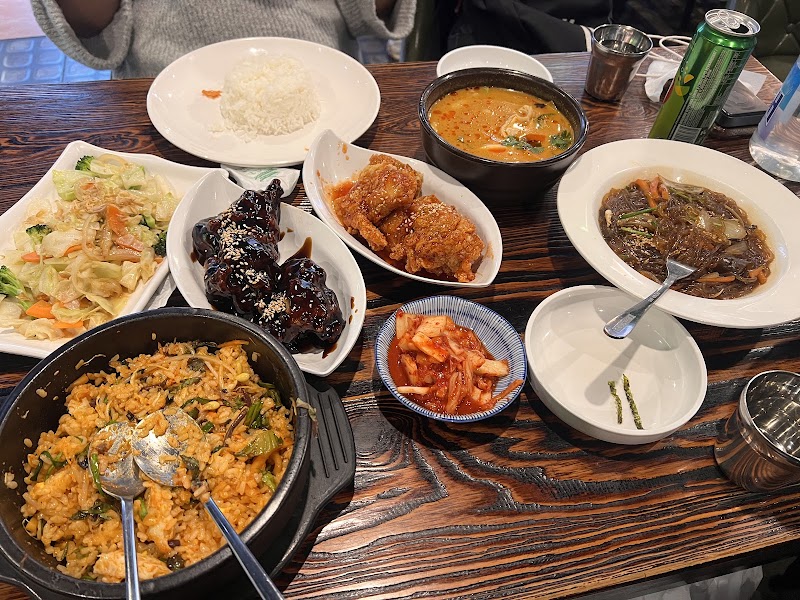 Full table spread of shared fried rice, chicken, and Asian comfort side dishes