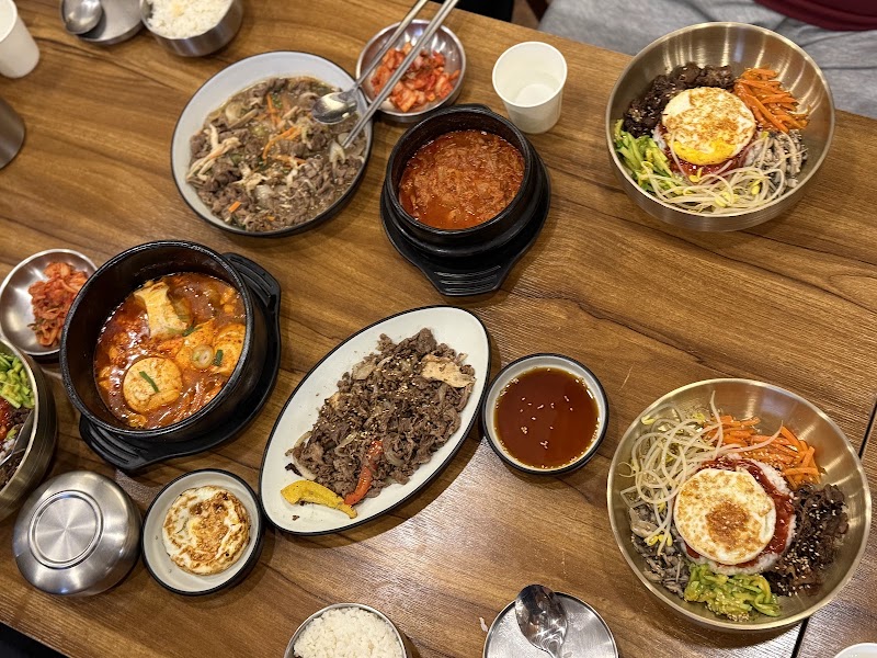 Bibimbap served with seasoned vegetables, beef, and fried egg in brass bowl