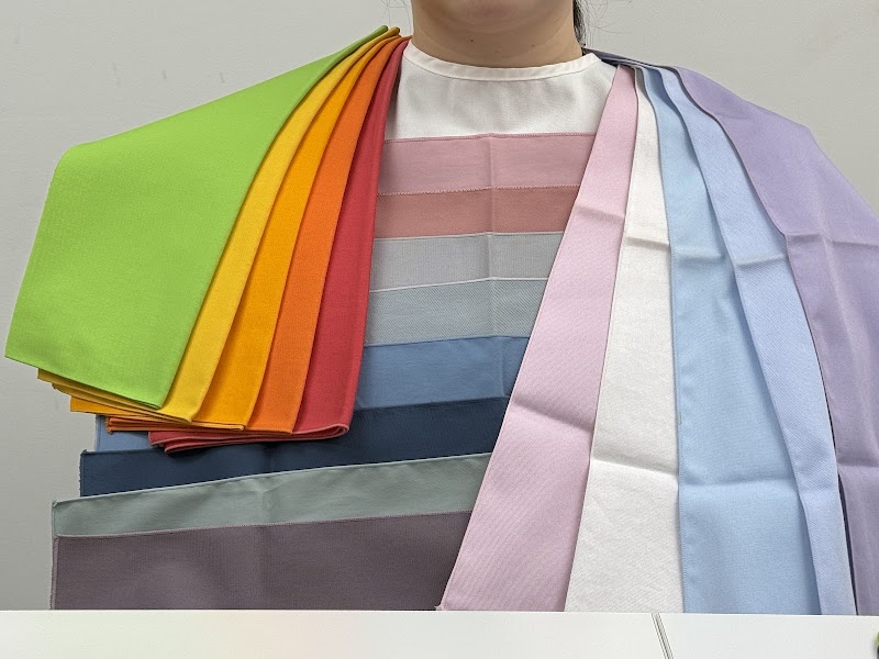 A person draped with various colored fabric swatches for a personal color analysis consultation