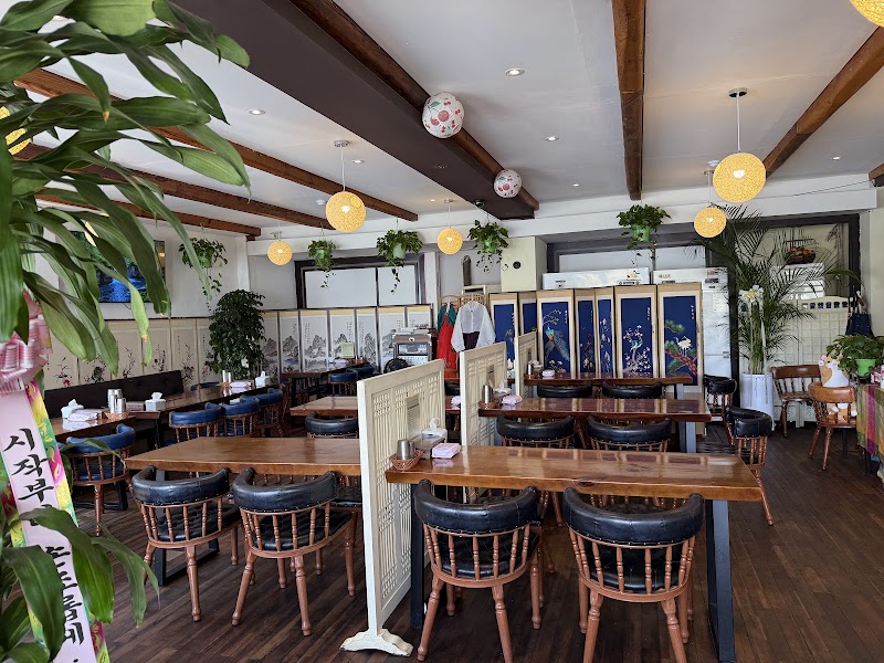 Dining room interior at Cherry Garden Restaurant showing wooden beam ceilings and folding screens