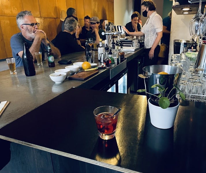 View of the bar counter inside with patrons and bartender service