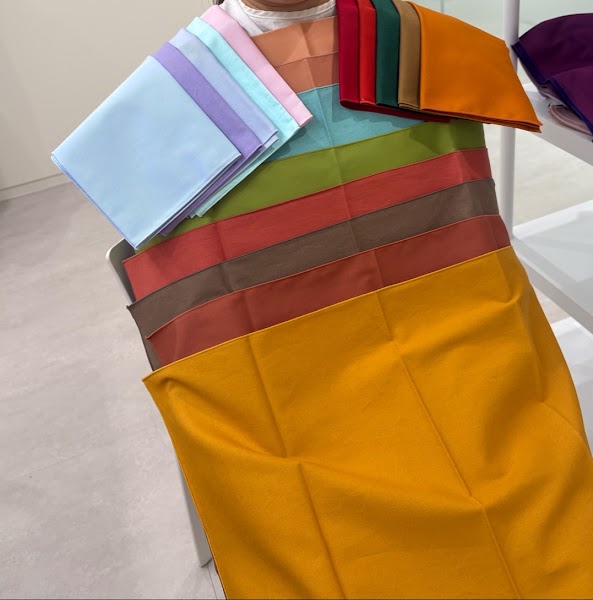 Selection of colorful fabric swatches used for personal color analysis in a professional studio setting