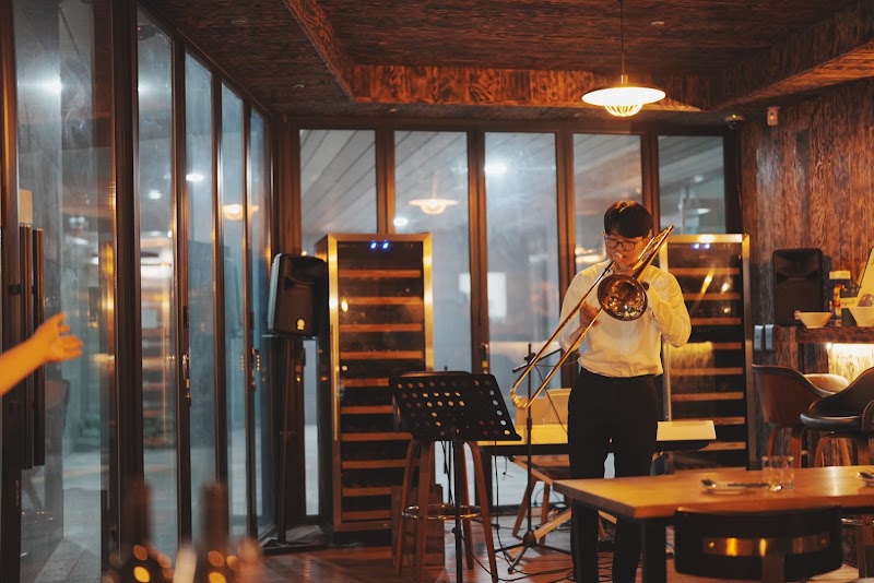 Live jazz musician playing trombone inside the wood-paneled tasting room at Andante Vino