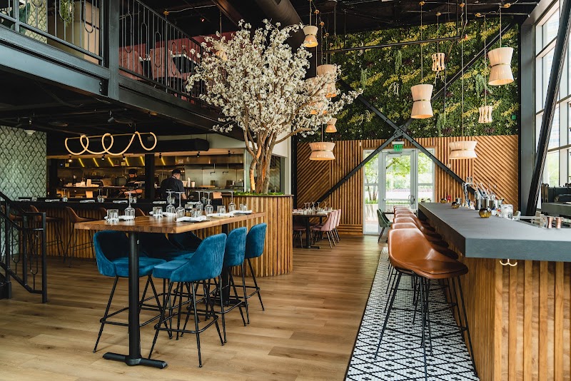 Sophisticated warm industrial interior of Ember Kitchen with dynamic blue seating structures.