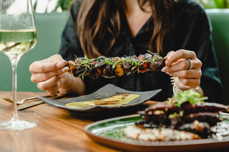 Ember grilled meat skewers decorated with microgreens and served fresh.