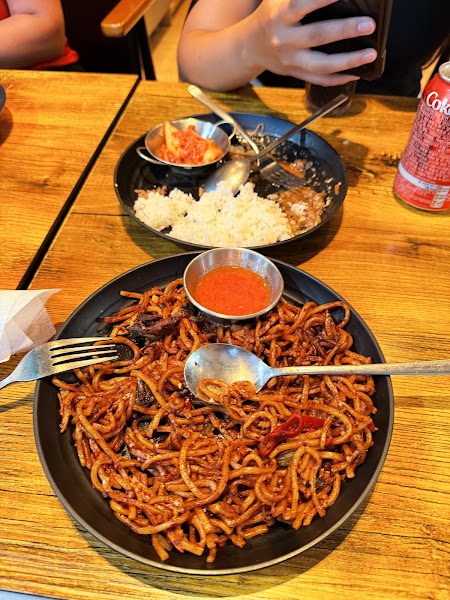 Stir-fried noodles and rice served with fresh kimchi side dishes.