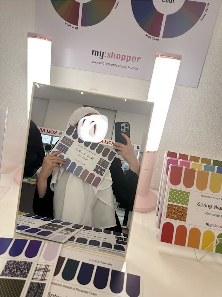 Personal color consultation swatch card held in front of studio mirror