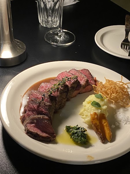 Sliced steak with mashed potatoes and seasonal accompaniments