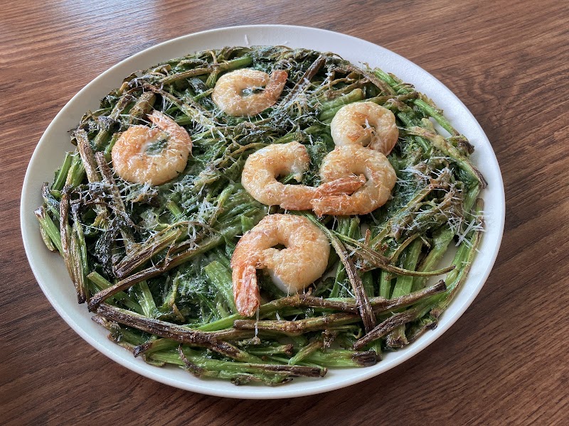 Pan-fried green herb pancake topped with whole succulent shrimp and shredded cheese