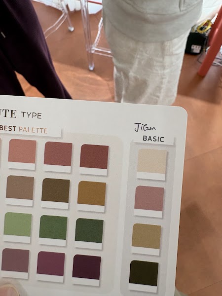 Close-up of personal color analysis palette card with fabric swatches and handwritten stylist notes