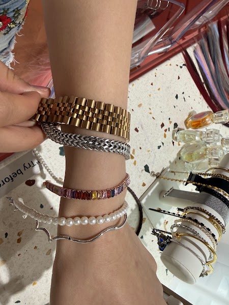 Close-up of wrist wearing gold, silver, crystal, and pearl bracelets for personal tone assessment