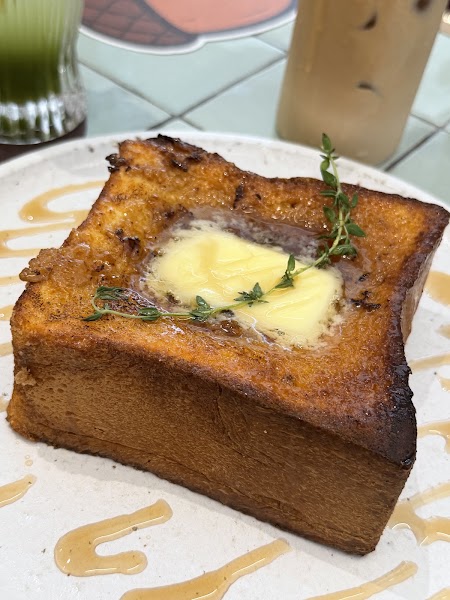 Thick-cut French toast topped with butter pat and fresh thyme