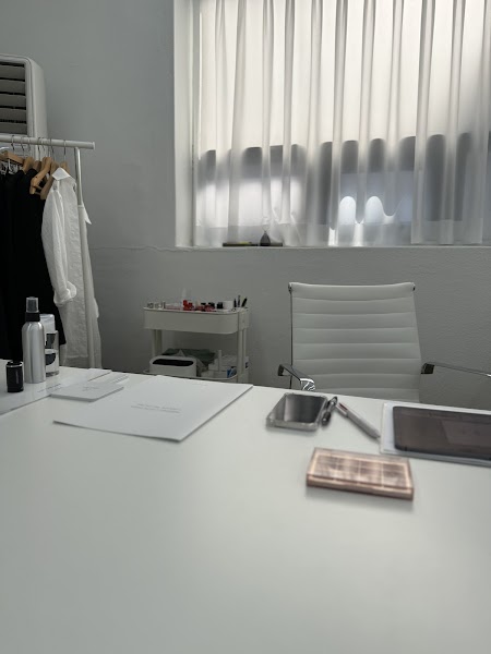 Minimalist consulting office interior with a white desk and curtained window at Coloryeon in Gangnam, Seoul.