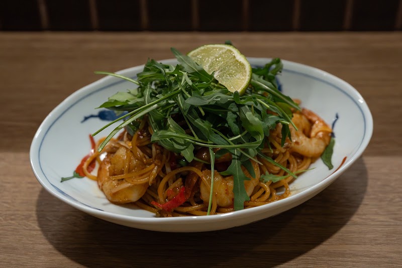 Shrimp pasta garnished with fresh wild arugula and fresh lime