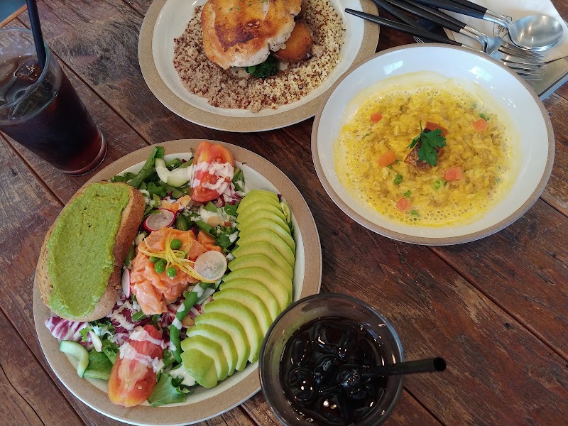 Three brunch dishes and two glasses of iced coffee served on a rustic wooden table at La FERME in Seoul.
