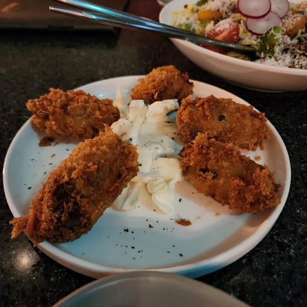 A plate of fried appetizers served with a white dipping sauce