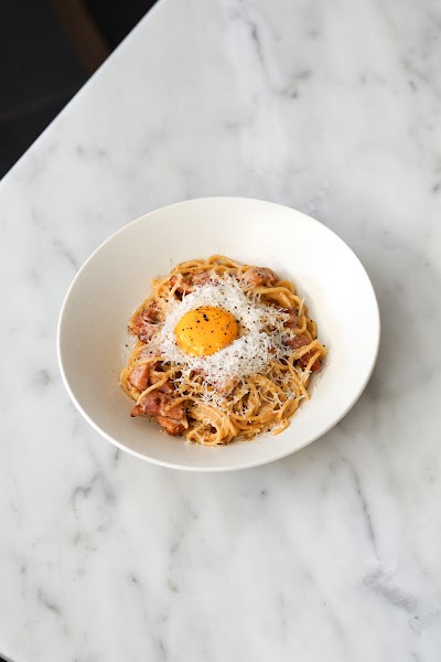 Fresh pasta carbonara served with cured pork, black pepper, and rich egg yolk