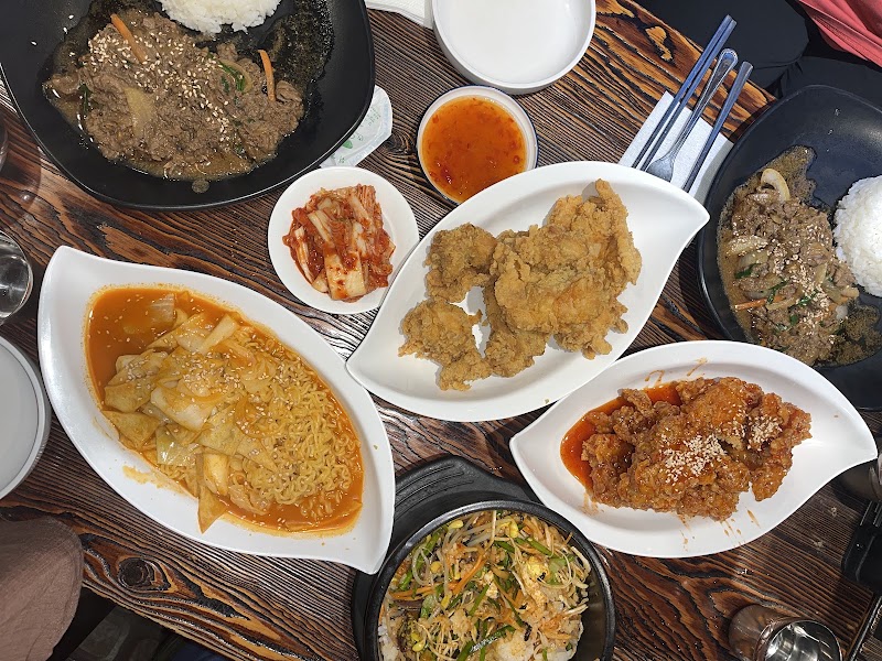 Table spread with bibimbap in hot stone bowl, bulgogi, and side dishes